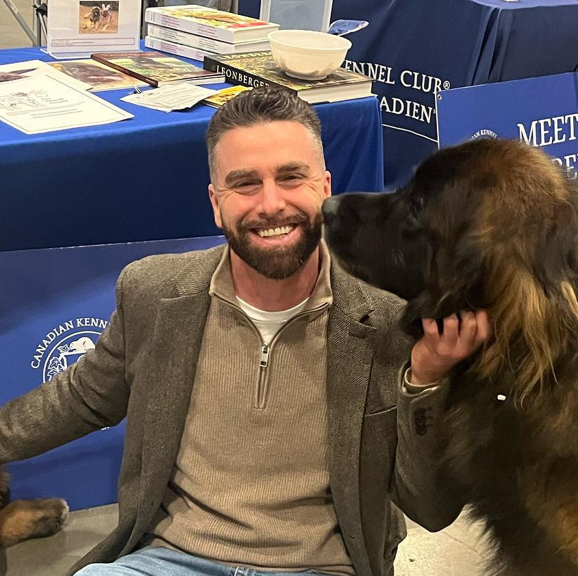 Ian Lynch at a Canadian Kennel Club Meet the Breeds booth with a Leonberger